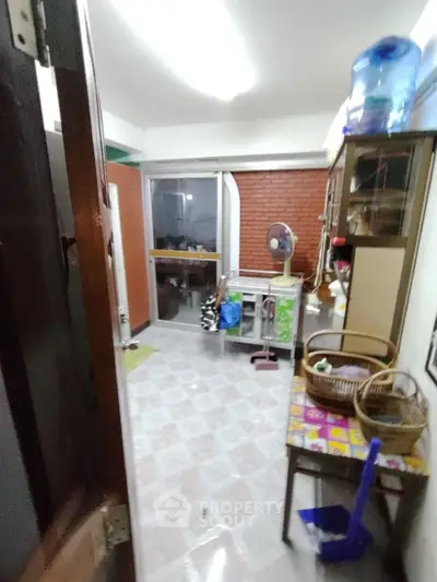 Spacious and versatile interior space with tiled flooring, ample storage options, and a cozy brick wall accent, ideal for creative layout designs.