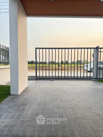 Modern gated entrance with tiled flooring and scenic view