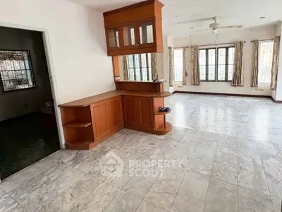 Spacious living room with marble flooring and wooden cabinetry