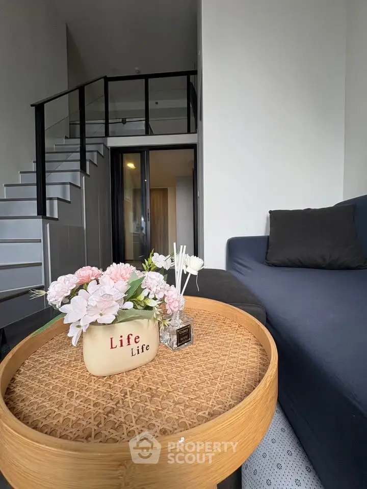 Modern living room with stylish staircase and cozy seating area, perfect for urban living.