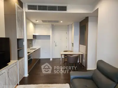 Modern open-plan living room with sleek kitchen and stylish furnishings in a contemporary apartment.