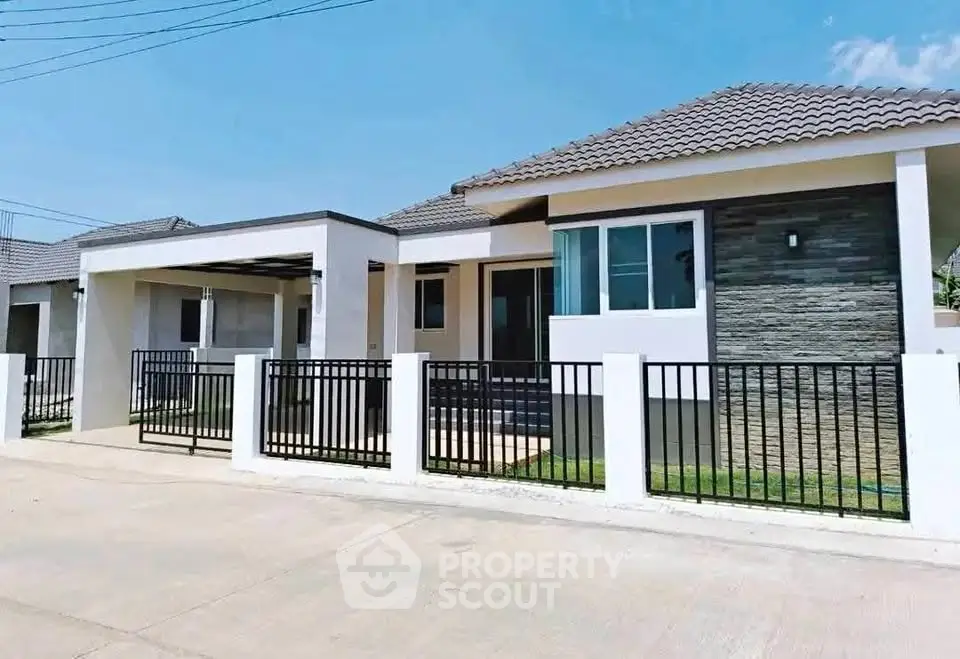 Modern single-story house with tiled roof and fenced yard