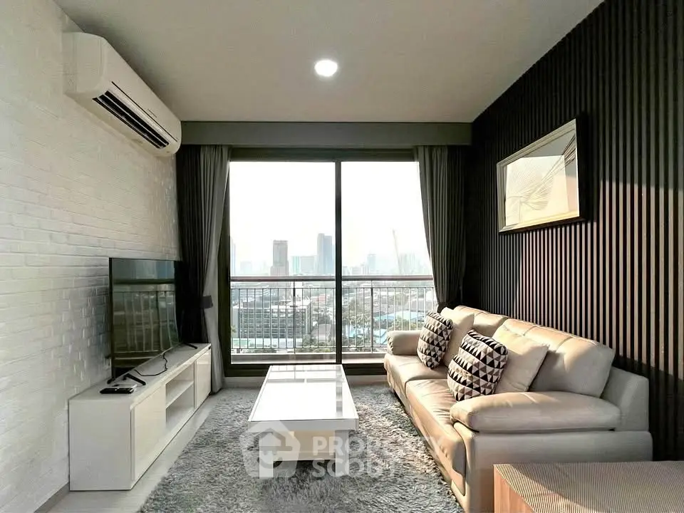 Modern living room with city view, featuring sleek furniture and large window for natural light.