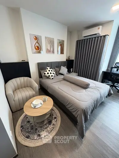 Modern bedroom with stylish decor and cozy seating area, perfect for relaxation.
