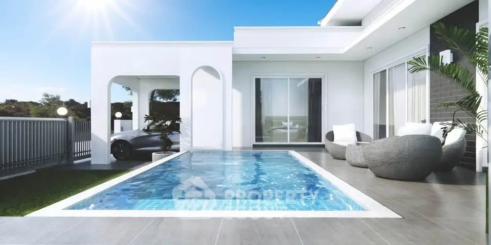 Luxurious modern villa with private pool and stylish outdoor seating area under clear blue sky.
