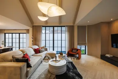 Luxurious living room with modern lighting, spacious seating, and elegant decor, perfect for relaxation and entertainment.