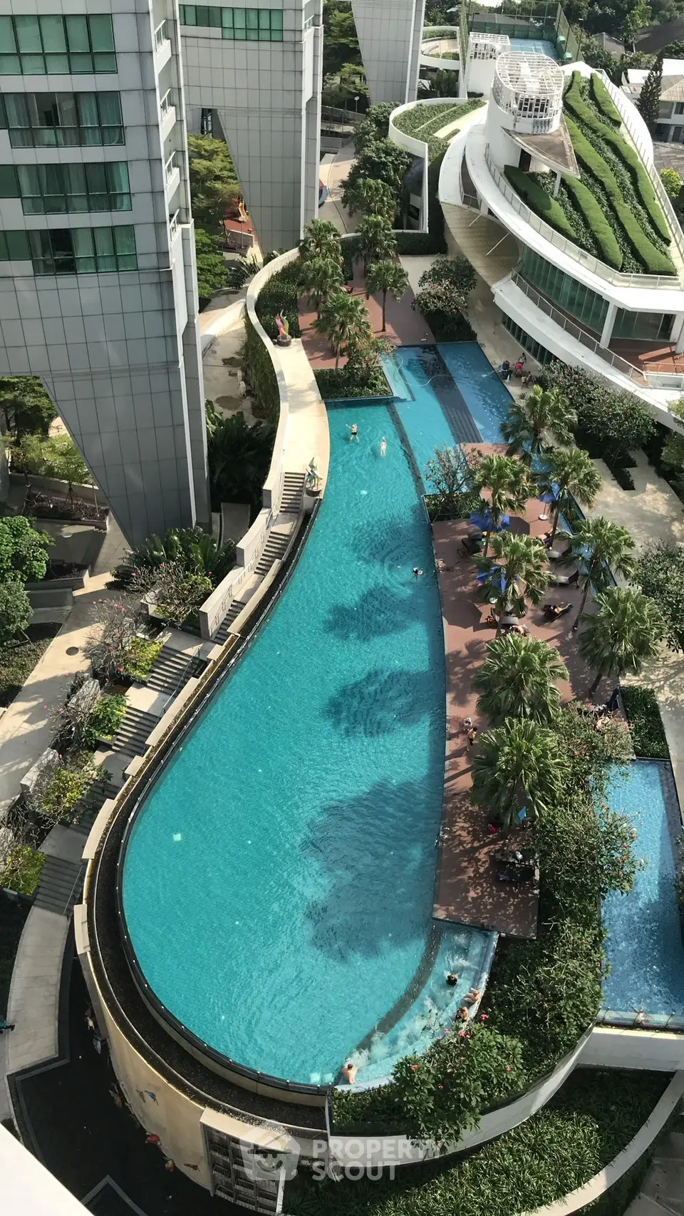 Luxurious rooftop pool with lush greenery and modern architecture, perfect for relaxation and leisure.