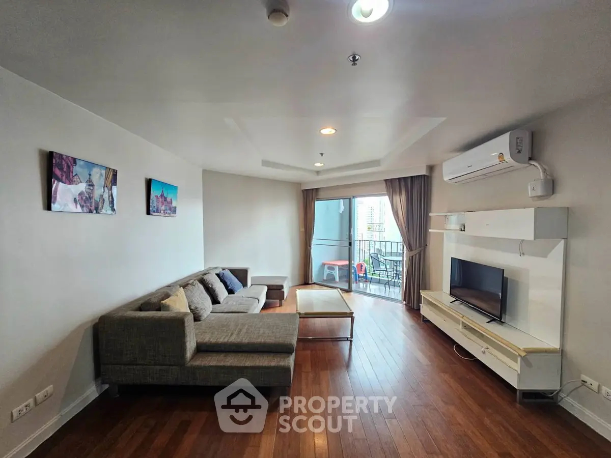 Spacious living room with modern decor and balcony view in a stylish apartment.