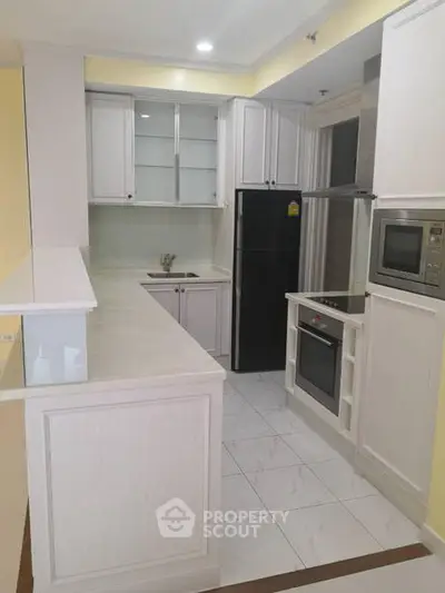 Modern kitchen with sleek cabinetry, built-in oven, and spacious countertops in a stylish apartment.