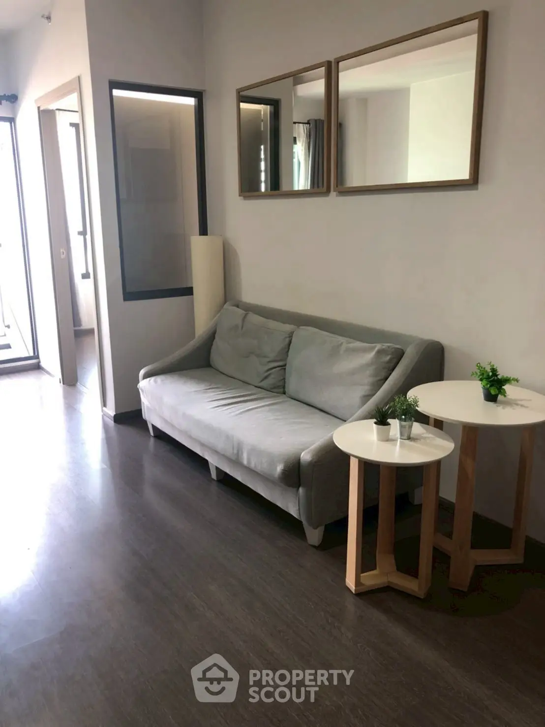 Modern living room with sleek sofa and stylish side tables in a bright apartment.