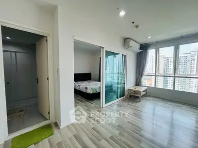 Spacious modern apartment with bedroom and living area, featuring large windows and city views.