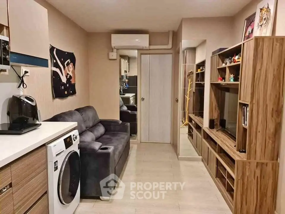 Cozy living room with modern decor and washing machine in compact apartment.