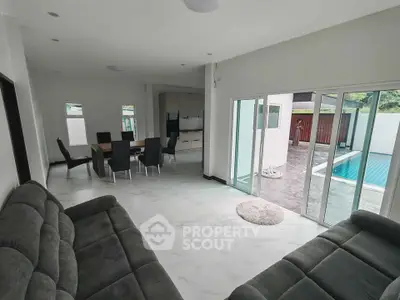 Spacious living room with pool view and modern dining area