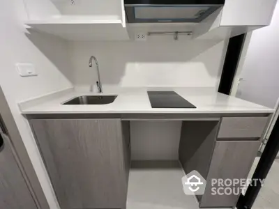 Modern compact kitchen with sleek countertop and built-in electric stove