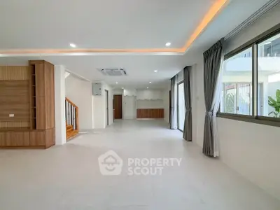 Spacious modern living room with large windows and elegant lighting