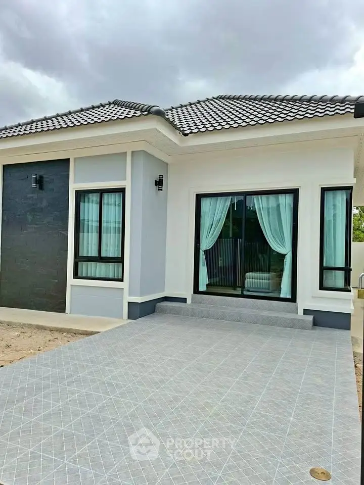 Charming modern house exterior with tiled driveway and elegant windows.