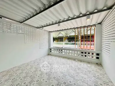 Spacious covered balcony with decorative tiles and open view of traditional houses.