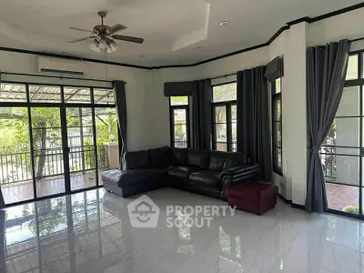 Spacious living room with large windows and modern furniture, perfect for family gatherings.