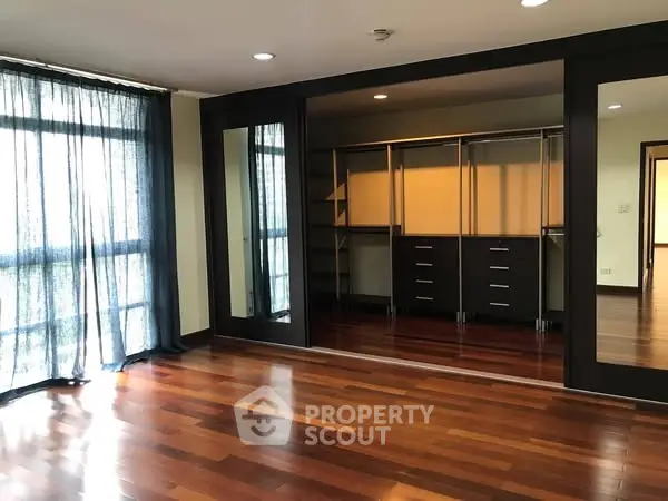 Spacious bedroom with hardwood floors and built-in closet