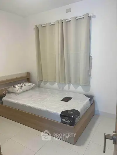 Cozy bedroom with single bed and neutral decor, perfect for minimalist living.