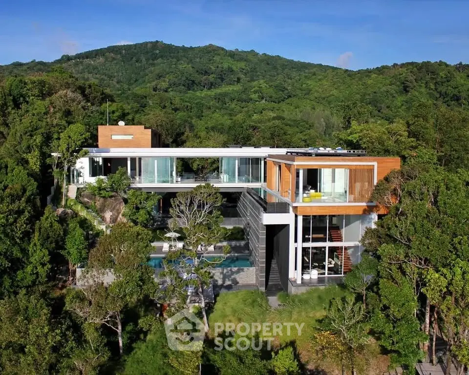 Luxurious modern hillside villa with stunning panoramic views and expansive glass windows.