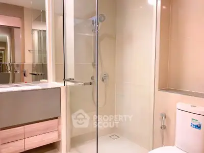 Modern bathroom with glass shower and sleek fixtures in a contemporary apartment.