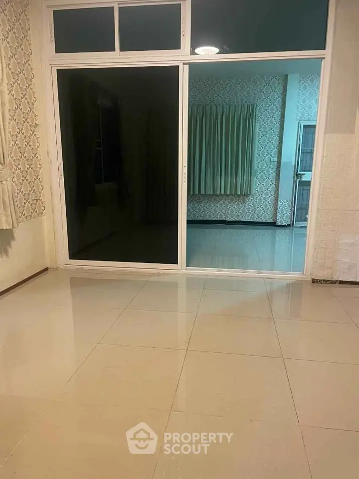 Spacious interior with large sliding glass doors and elegant wallpaper, perfect for modern living.