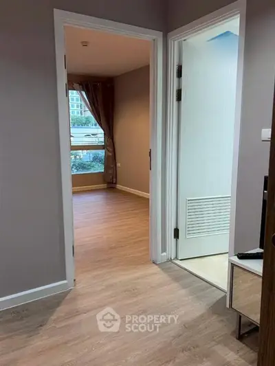 Spacious apartment interior with wooden flooring and natural light.