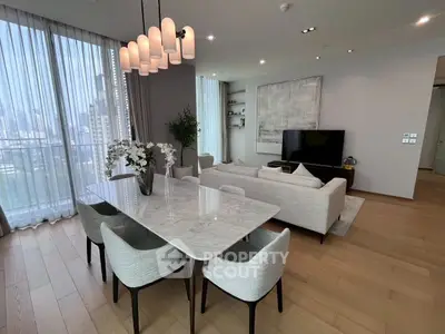 Luxurious modern living room with elegant dining area and city view, featuring chic decor and ample natural light.
