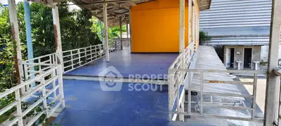 Spacious outdoor terrace with vibrant orange wall and metal railings, perfect for gatherings or relaxation.