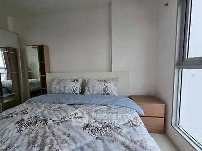 Cozy bedroom with floral bedding and natural light from large window