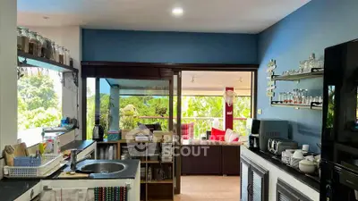Spacious open kitchen with modern appliances and a view of the lush outdoor patio.