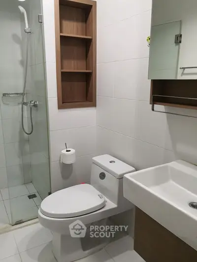 Modern bathroom with glass shower and sleek fixtures in contemporary home.