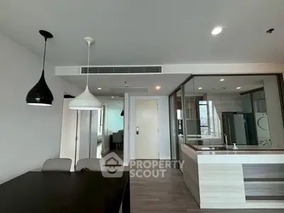 Modern open-plan kitchen and dining area with stylish lighting and sleek design.