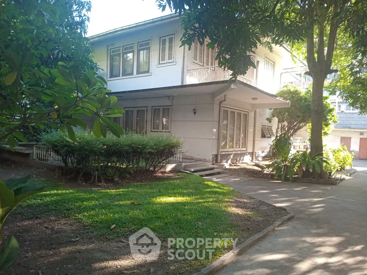Charming two-story house with lush garden and spacious driveway in a serene neighborhood.