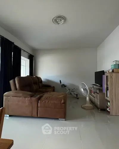 Spacious living room with brown leather sofa and modern entertainment unit