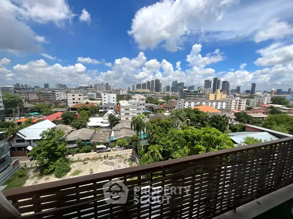 Stunning cityscape view from a high-rise balcony with lush greenery and skyline.