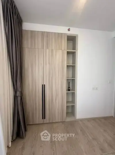 Modern minimalist bedroom with sleek wooden wardrobe and elegant curtains