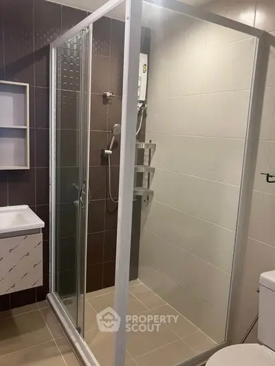 Modern bathroom with glass shower enclosure and sleek fixtures.