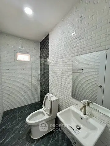 Modern bathroom with sleek design, featuring white brick tiles and contemporary fixtures.