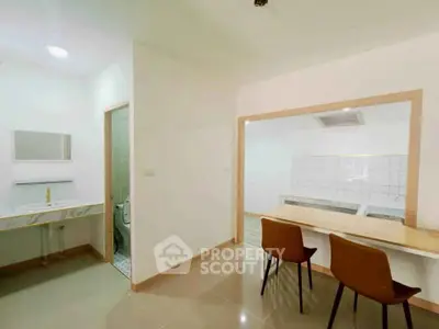 Modern open-plan kitchen with dining area and adjacent bathroom.