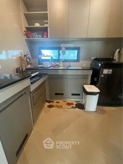 Modern kitchen with sleek cabinetry and appliances, featuring a compact layout and stylish design.