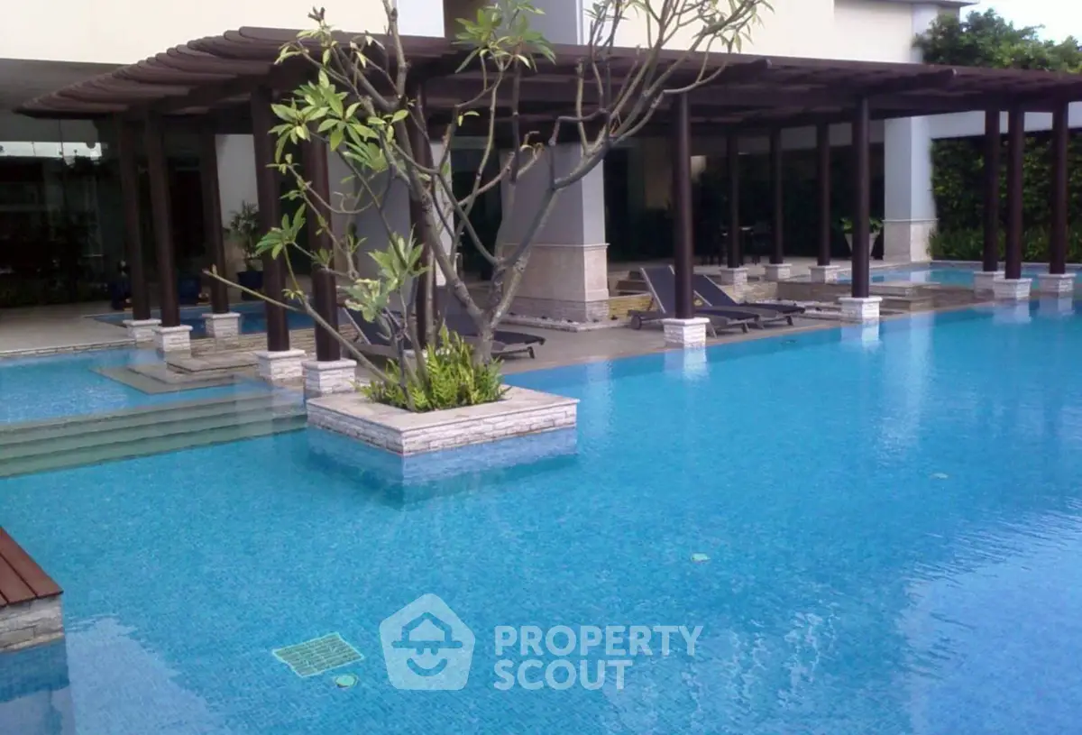 Luxurious outdoor pool area with modern design and lush greenery, perfect for relaxation and leisure.