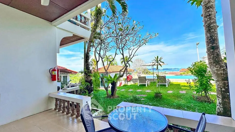 Stunning garden view from a patio with pool access and ocean backdrop.