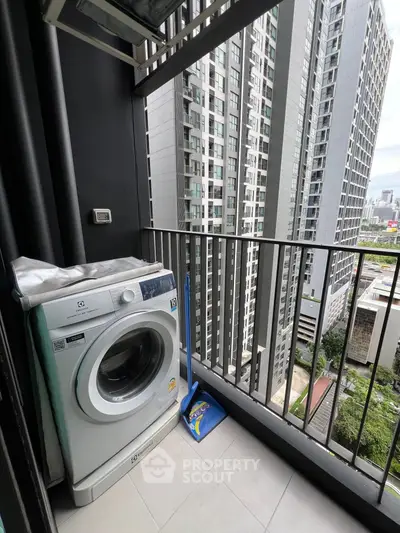 Compact balcony with washing machine and city view in modern high-rise apartment.