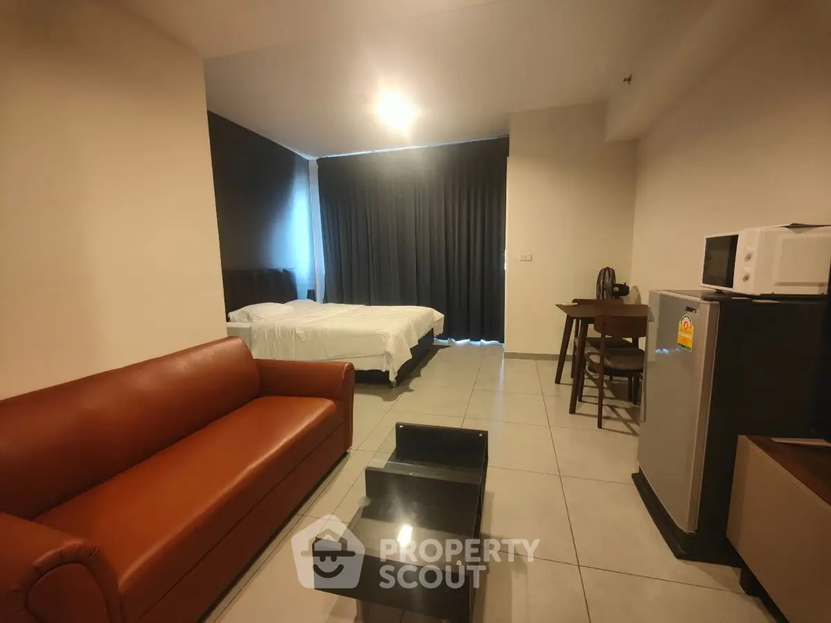 Modern studio apartment with cozy living area and kitchenette, featuring a comfortable bed and stylish furnishings.