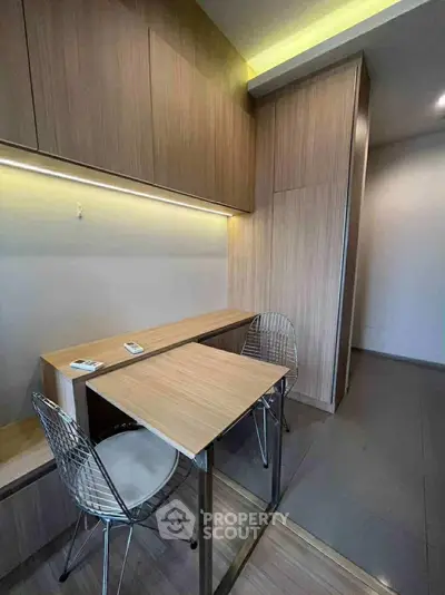 Modern study area with sleek wooden furniture and stylish chairs in a contemporary apartment.
