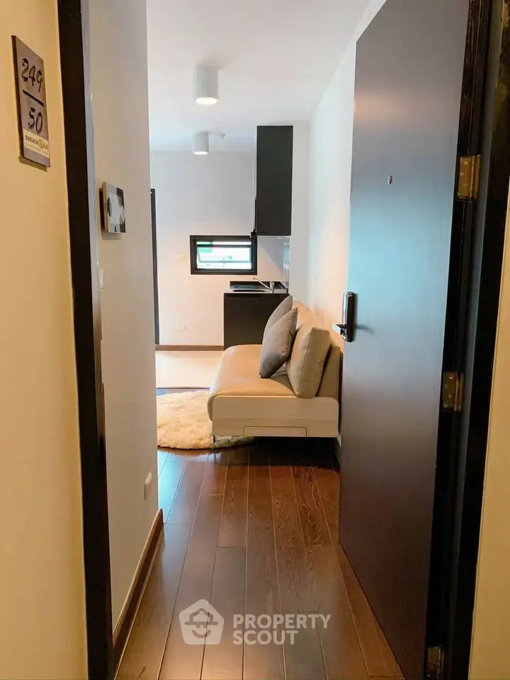 Modern apartment entrance with cozy living area and sleek wooden flooring.
