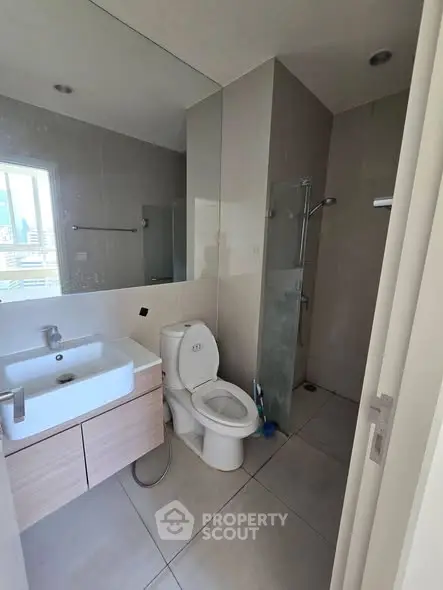 Modern bathroom with sleek fixtures and large mirror in a contemporary apartment.