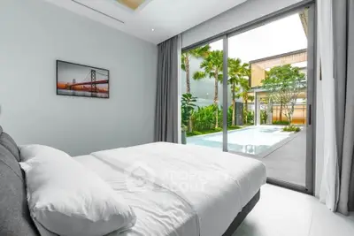 Luxurious bedroom with pool view and modern decor in a serene setting.